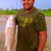 Oscar Viteri of Houston hefts his nice red he caught on finger mullet.