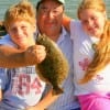 Grandpa Sherman West with grandkids; Jatham and Madison of Sourlake, TX show off this nice flounder.