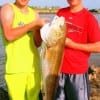 Fishin buds Connor Gage and Graison Kuhl of Talco TX heft this HUGE 38 inch tagger Bull Red caught on finger mullet