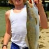 Braedon Rayon of Devers TX hefts this 25 inch, 7 lb speckled trout caught on a finger mullet